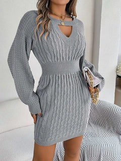 Gray cable-knit cutout sweater dress with round neck and long sleeves, featuring slit and fitted waist detail