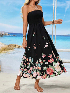 Printed tube midi dress with floral design, sleeveless, black polyester fabric, beach background.