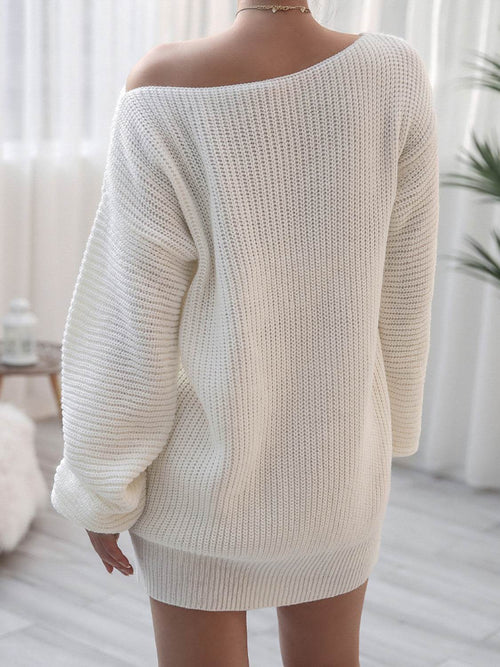 Back view of woman wearing white rib-knit mini sweater dress with off-shoulder design in a bright room