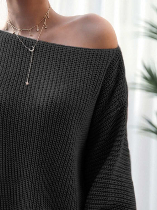 black rib-knit mini sweater dress with off-shoulder neckline and layered gold necklaces