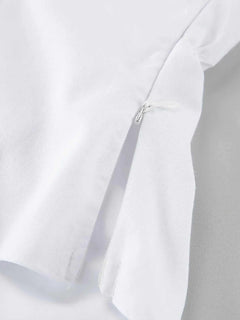Close-up of white cotton fabric with a hidden zipper detail on a ruffled V-neck maxi dress