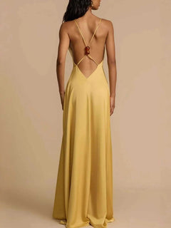 Back view of a yellow deep V-neck maxi dress with backless and crisscross strap design.