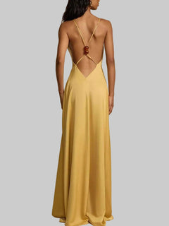 Back view of a yellow deep V-neck maxi dress with backless and crisscross strap design.