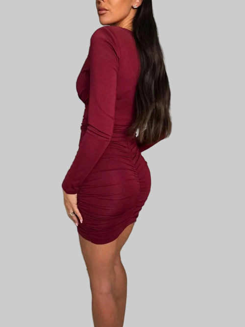 Ruched plunge long sleeve wrap dress in maroon, showcasing a fitted silhouette with ruching detail.