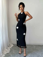 Black flower halter neck dress with white floral accents and tassel hem