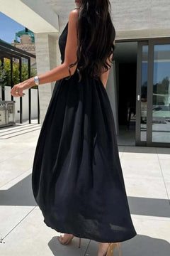 Surplice sleeveless slit maxi dress in black polyester, outdoor setting.