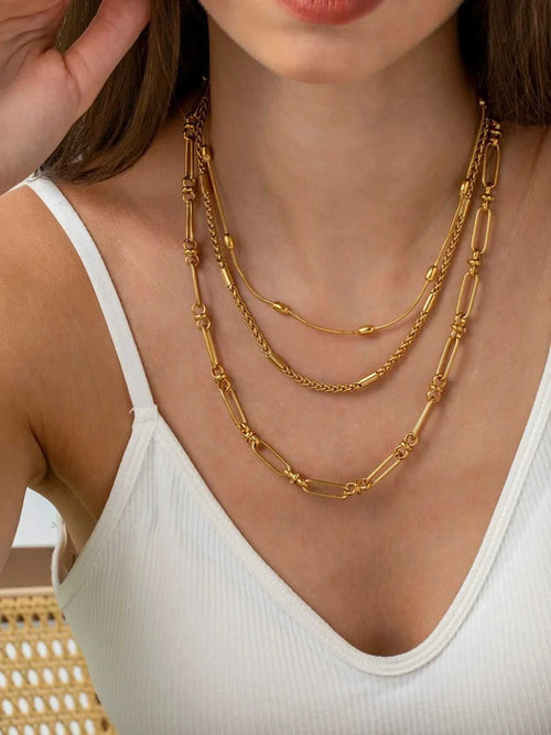 18K gold-plated layered chain necklace and bracelet jewelry set on woman wearing white top
