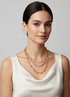 18K gold-plated layered chain necklace and bracelet jewelry set on woman wearing white top