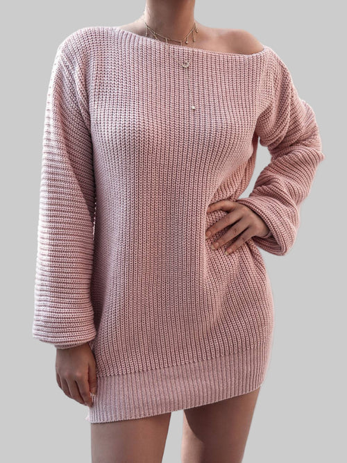 Woman wearing a pink rib-knit mini sweater dress with long sleeves and a slightly off-shoulder neckline
