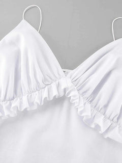 Close-up of white ruffled V-neck maxi dress with frill detail and thin straps made of 100% cotton.
