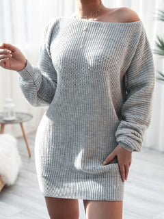 Woman wearing a gray rib-knit mini sweater dress with long sleeves and off-shoulder neckline in bright indoor setting