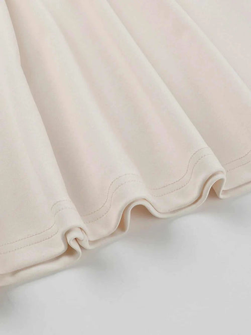 Close-up of cream asymmetrical tied sleeveless maxi dress fabric hem detail