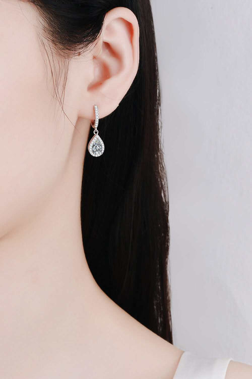 Close-up of a woman's ear wearing 2-carat moissanite teardrop earrings in rhodium-plated 925 sterling silver with zircon accents.
