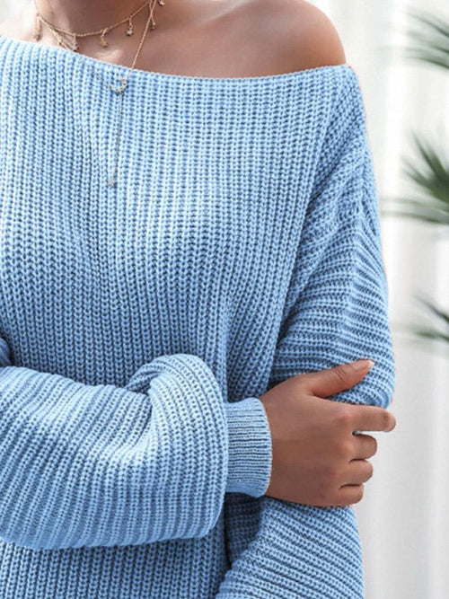 Close-up of light blue rib-knit mini sweater dress with off-shoulder neckline and long sleeves in acrylic fabric