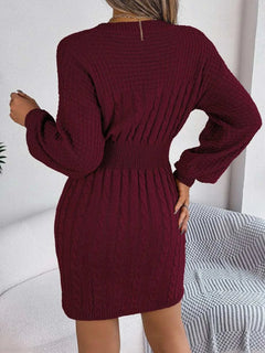 Back view of a burgundy cable-knit cutout round neck slit sweater dress with long sleeves and fitted waist.