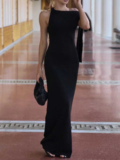 Black asymmetrical tied sleeveless maxi dress with a fitted silhouette and floor-length hem.