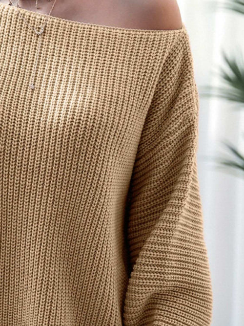 Close-up of a beige rib-knit mini sweater dress with a slightly stretchy off-shoulder design made from 100% acrylic material.