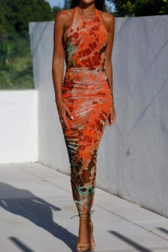 Backless printed halter neck dress in vibrant colors, featuring a fitted silhouette and ankle length design.