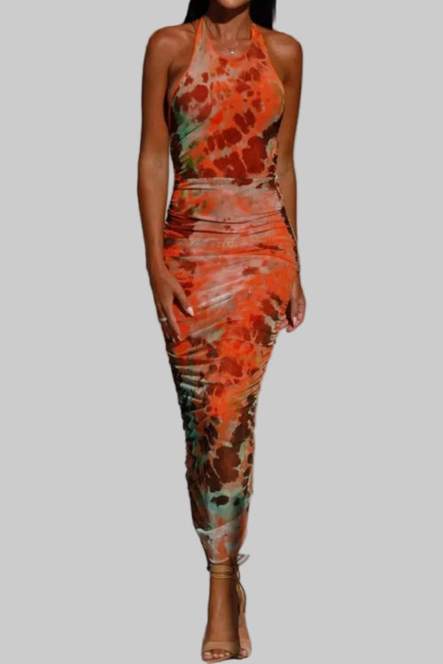Backless printed halter neck dress in vibrant colors, featuring a fitted silhouette and ankle length design.