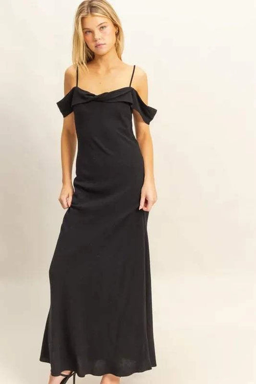 Woman wearing a black HYFVE Flattering Fit Cami Maxi Dress with ruffled asymmetrical neckline and slim silhouette.