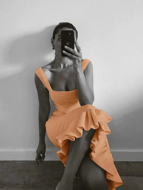 Woman wearing ribbed knit bodycon dress with ruffle hem taking a mirror selfie