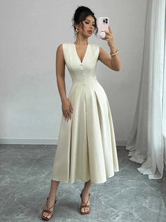 Woman wearing a buttoned V-neck sleeveless midi dress in cream color taking a mirror selfie