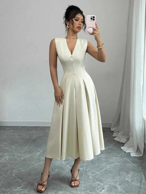 Woman wearing a buttoned V-neck sleeveless midi dress in cream color taking a mirror selfie