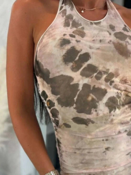 Backless printed halter neck dress in earthy tones.