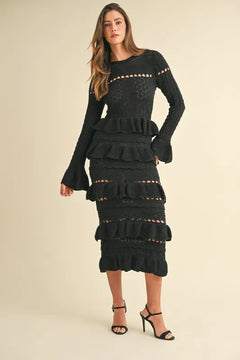 Long sleeve tiered ruffle knit midi dress in black with cutout details.