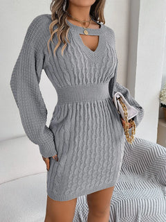 Gray cable-knit cutout sweater dress with round neck and long sleeves, featuring slit and fitted waist detail