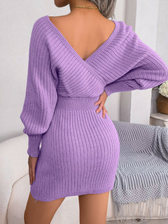 Back view of purple rib-knit dolman sleeve mini sweater dress with surplice neckline and A-line hem