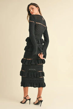 Long sleeve tiered ruffle knit midi dress in black worn by model.