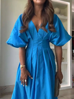 Woman wearing a blue V-neck half sleeve midi dress with ruched detail and backless design