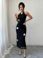 Black flower halter neck dress with white floral accents and tassel hem