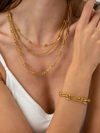 18K gold-plated layered chain necklace and bracelet set on model wearing white top