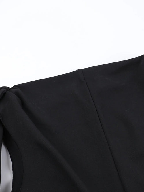 Close-up of black asymmetrical tied sleeveless maxi dress detail