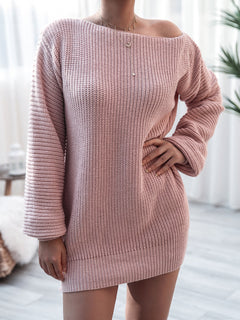 Woman wearing a pink rib-knit mini sweater dress with long sleeves and a slightly off-shoulder neckline