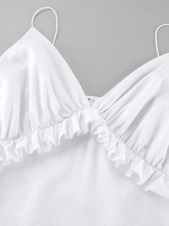 Close-up of white ruffled V-neck maxi dress with frill detail and thin straps made of 100% cotton.