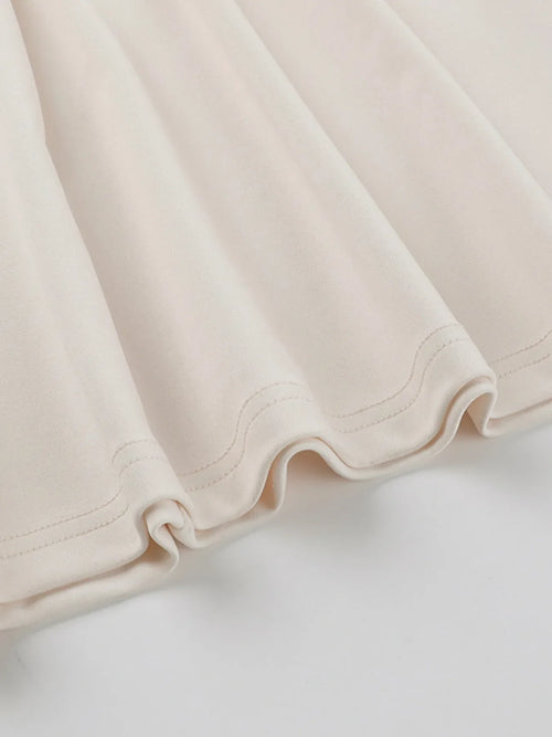 Close-up of cream asymmetrical tied sleeveless maxi dress fabric hem detail