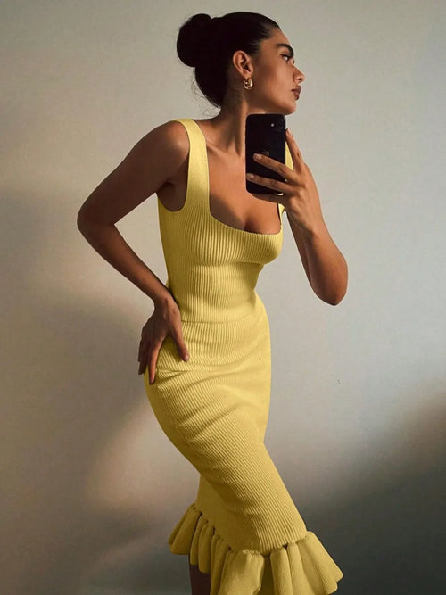 Yellow ribbed knit bodycon dress with ruffle hem worn by woman taking mirror selfie