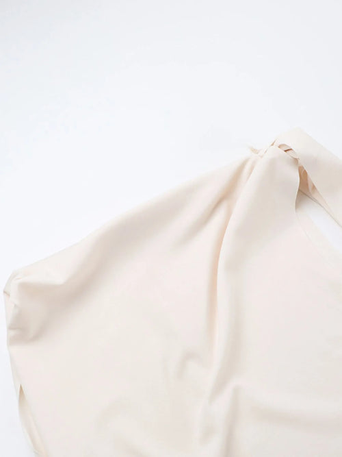 Close-up of an asymmetrical tied sleeveless maxi dress in soft beige polyester fabric