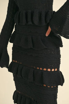 Long sleeve tiered ruffle knit midi dress with cable-knit and cutout details.