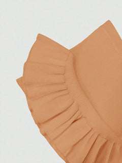 Close-up of ribbed knit bodycon dress in tan with ruffle hem detail