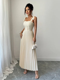 Elegant cream pleated tie-shoulder maxi dress with bow details and a fitted bodice