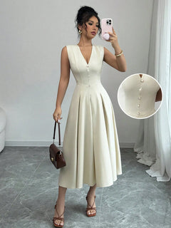 Woman wearing a white V-neck sleeveless midi dress with front button details and pleated skirt