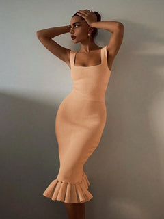 Woman wearing a beige ribbed knit bodycon dress with mermaid style and ruffle hem