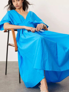 Woman wearing blue V-neck half sleeve midi dress sitting on chair