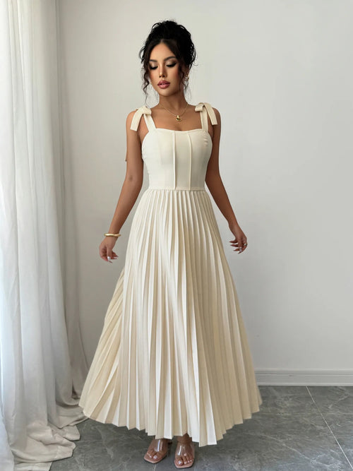 Elegant cream pleated tie-shoulder maxi dress with bow details and a fitted bodice