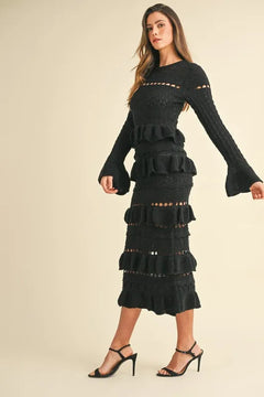 Long sleeve tiered ruffle knit midi dress in black worn by a model.