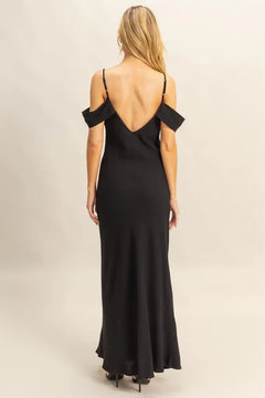 Rear view of a woman wearing a black HYFVE Flattering Fit Cami Maxi Dress with an asymmetrical ruffled design and low back, showcasing its sleek, maxi-length silhouette.